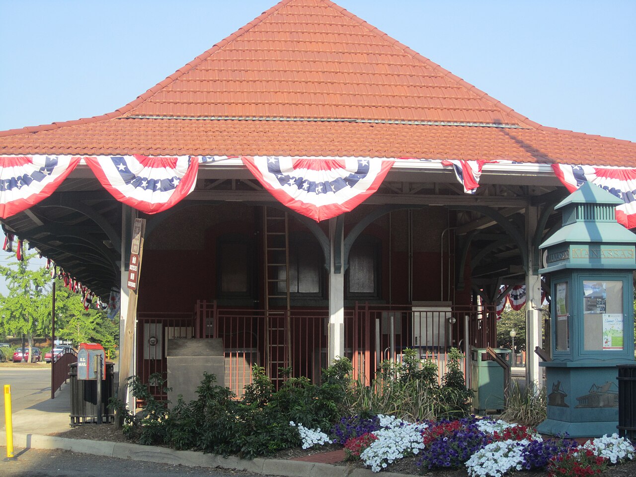 Historic Manassas Train Depot with a terracotta roof, patriotic bunting, and flowers.